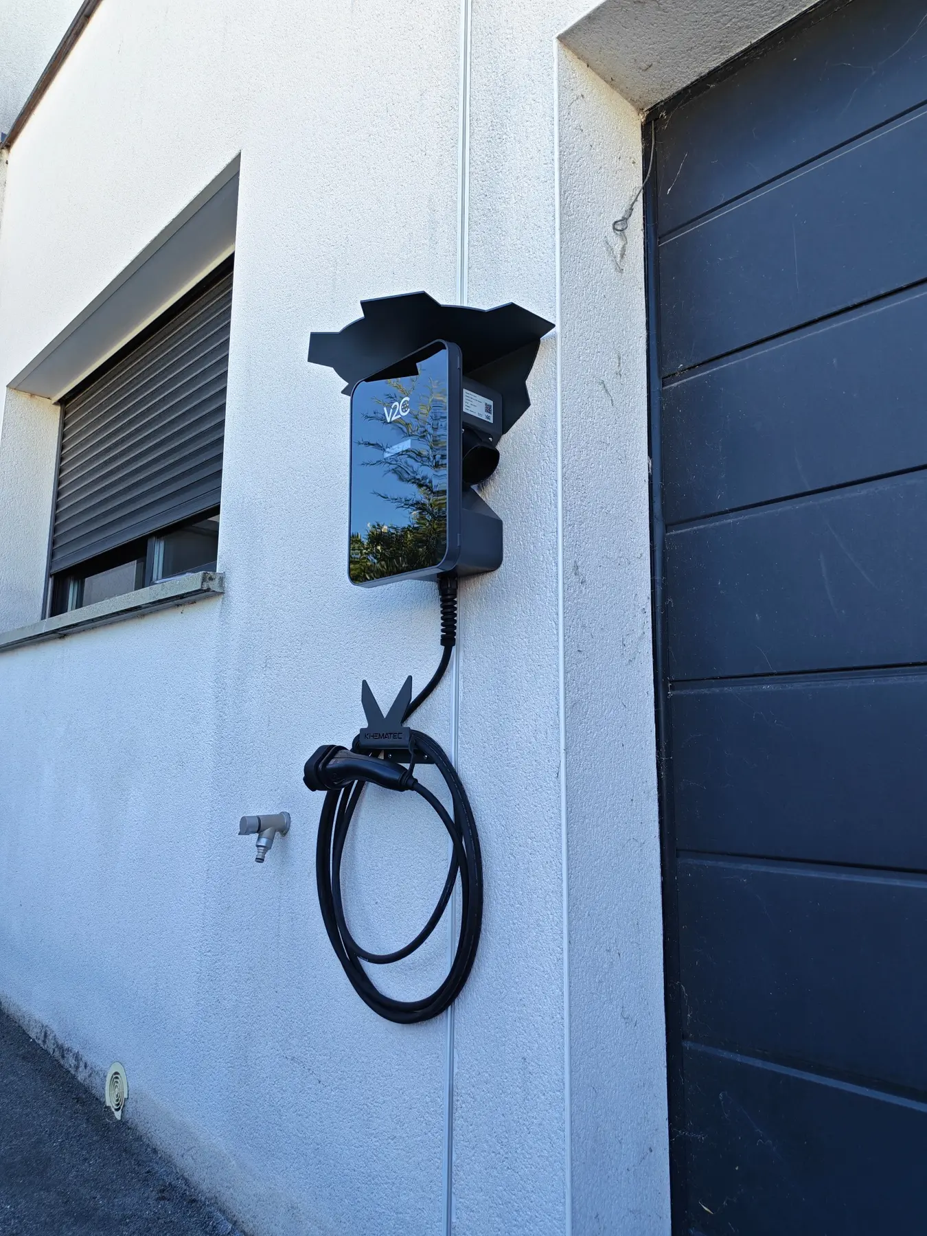 Vue latérale d’une borne V2C avec casquette de protection et support support de câble de recharge