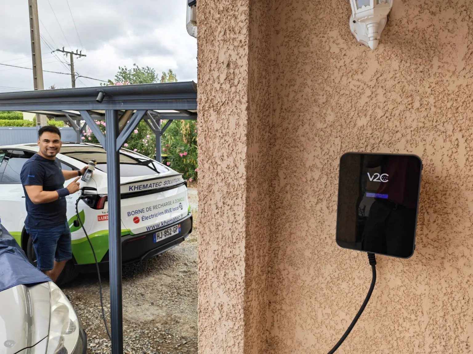 Installateur IRVE KHEMATEC devant une borne V2C Trydan et un véhicule électrique