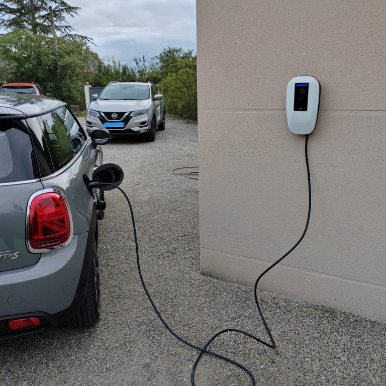Voiture électrique en charge à une station de recharge murale.