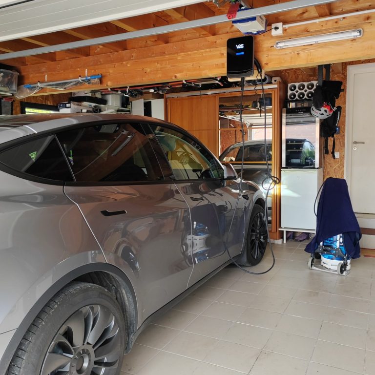 Installation de une borne de recharge IRVE en Haute-Garonne Voiture électrique grise chargée dans un garage bien rangé.
